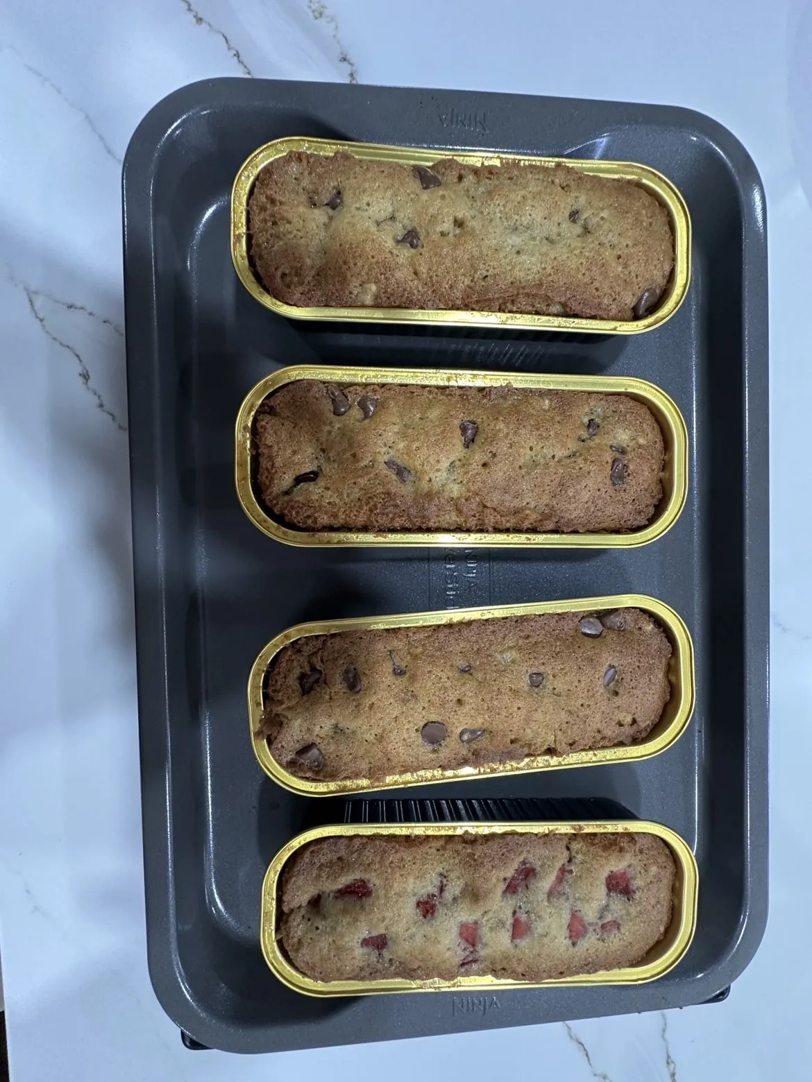 Four baked mini banana breads in gold loaf trays at Kassey's Kitchen