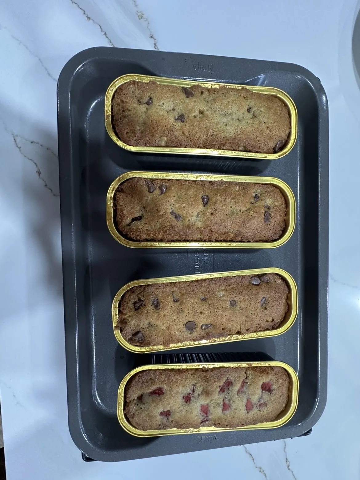 Baked mini banana breads with chocolate chips in gold loaf trays